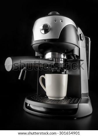 Modern coffee machine with white mug shot on black background