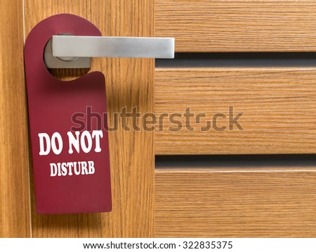 Do Not Disturb door hanger hanging on hotel room door handle