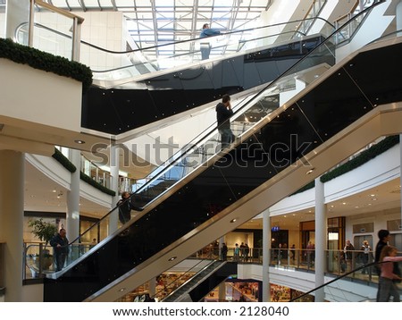 Shoppers in shopping mall using elevators