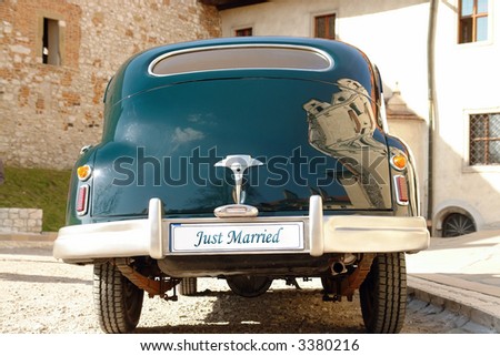 Rear of dark green retro wedding car with just married license plate