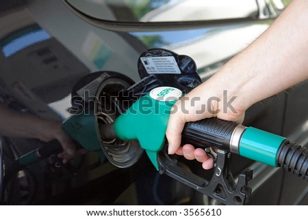 Closeup of male hand topping up car tank with unleaded 95 gasoline