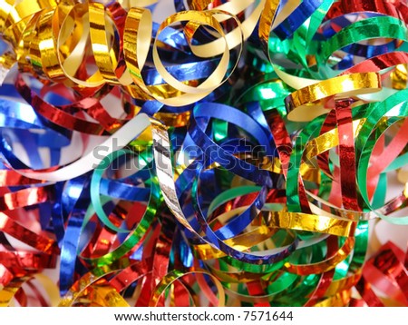 Closeup of twisted and tangled party streamers in blue, silver, red, green and golden color