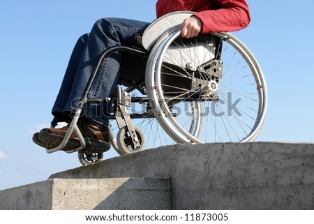 Closeup of wheelchair woman going down the concrete kerb