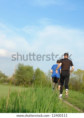 Men jogging along field path