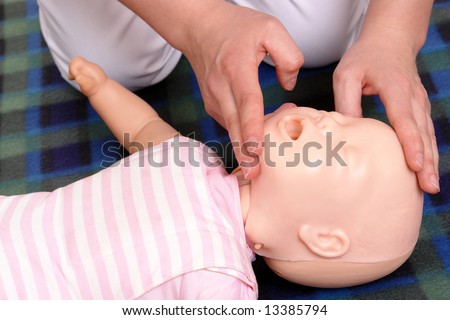 Infant dummy first aid demonstration series - First aid instructor showing how to position infant head before proceeding to mouth-to-mouth resuscitation
