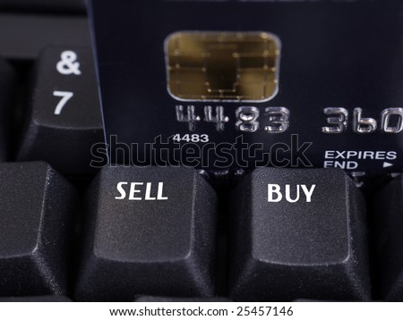 Closeup of two black keyboard keys with Sell and Buy words and microchip credit card in the background