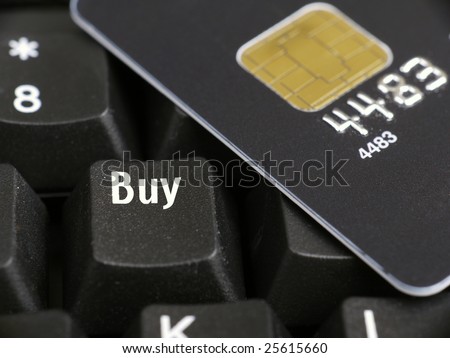 Closeup of black microchip credit card and computer keyboard key spelling Buy word