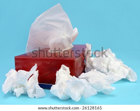Paper tissue box with used tissues over light blue background
