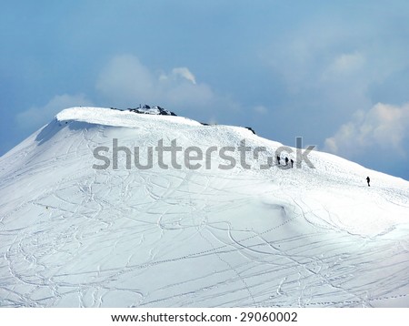 Group of tourists climbing mountain summit in winter