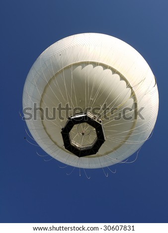 White hot air balloon rising up in the air