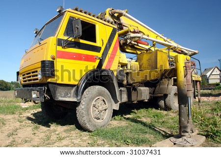 Yellow concrete mix pump truck parked at construction site
