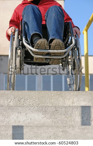 Wheelchair woman trying to go down the concrete stairs