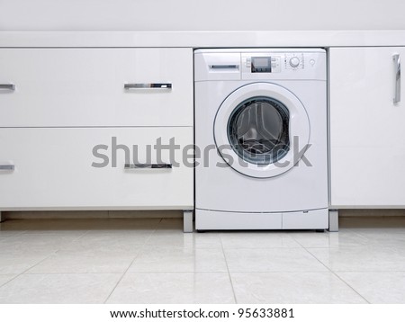 Modern bathroom with shiny white cabinets and washing machine