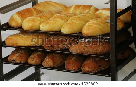 Freshly baked loaves of french bread behind a market stall