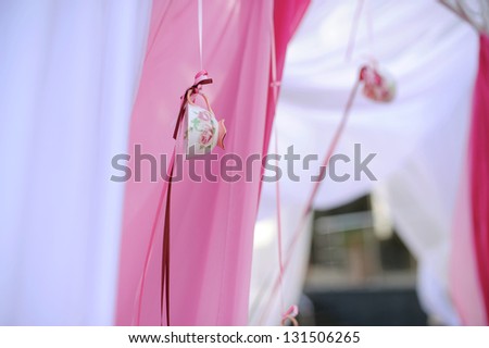 elegant tea cup hanging on pink ribbon