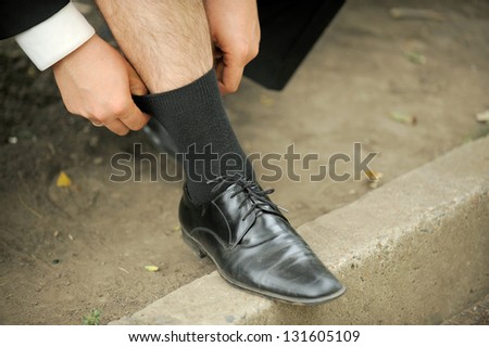 groom straining sock in park