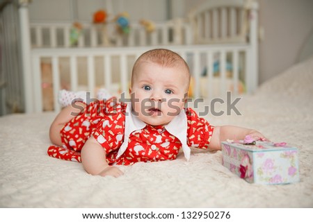 surprised baby with gift box on bed
