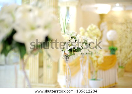 white lily bouquets on stands in restaurant