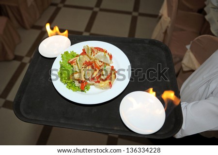 waiter serving plate with decorated fish