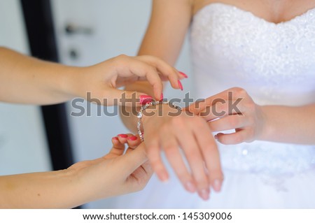 bridesmaid hands helping to put on bracelet