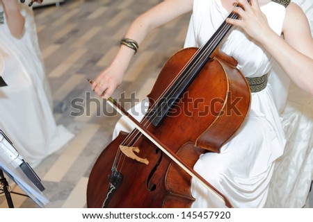 woman dressed in Greek style with cello