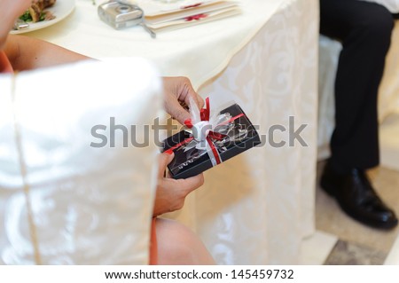 woman holding wedding gift box in restaurant