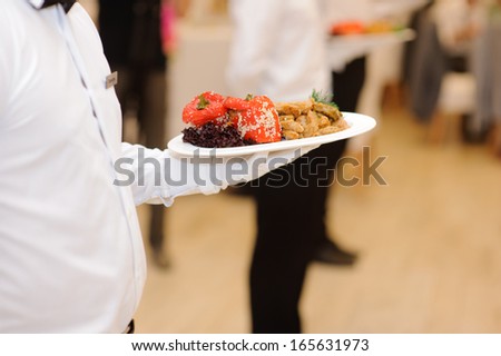 grilled vegetables on plate in waiter\'s hand