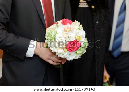 beautiful flowers in groom\'s hands
