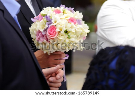 elegant bridal bouquet in groom\'s hand