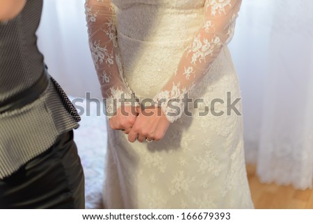 bridesmaid helping bride in wedding preparation