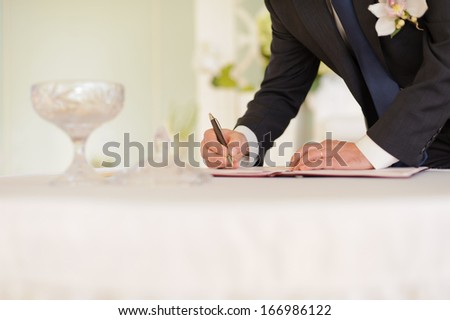groom signing marriage certificate at wedding ceremony