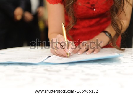 bridesmaid in red dress signing certificate