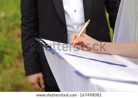 bride signing marriage certificate at ceremony