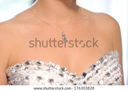 silver chain with crystal pendant on bride\'s neck