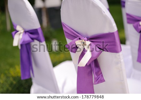 chairs decorated with violet ribbon and crystal
