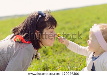 daughter giving dandelion to her mother to smell