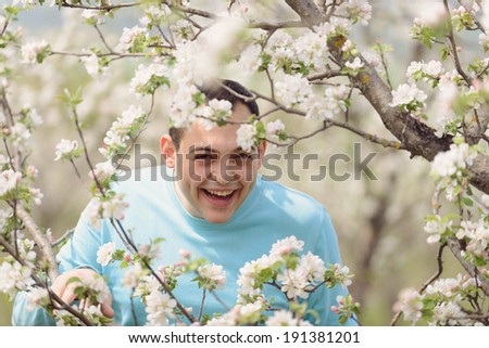 laughing man in blossoming tree branches
