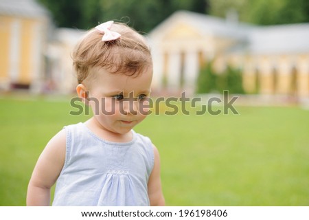 charming girl in blue dress in yard