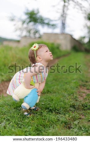 angry little girl holding her teddy bear