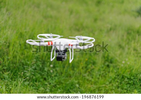 flying helicopter with camera over meadow