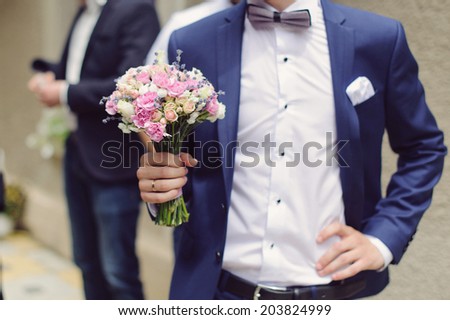 groom holding elegant wedding bouquet