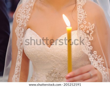 bride holding candle in church