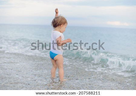 girl throwing stones in sea