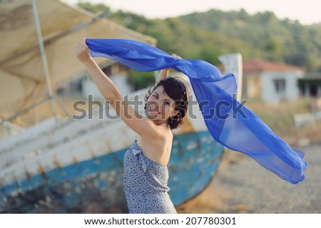 young woman holding flying scarf