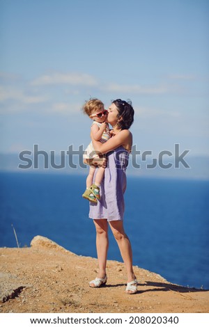 mother kissing her daughter at seaside