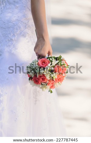 bride's hand holding rose bouquet