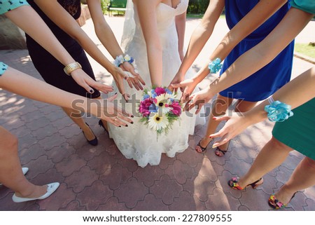bride and bridesmaids admiring wedding bouquet