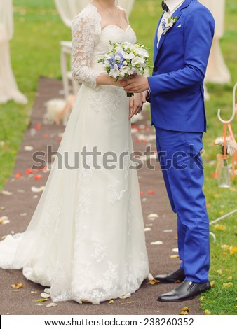 newlyweds standing on path with rose petals at ceremony