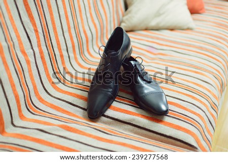 pair of shoes on striped bed