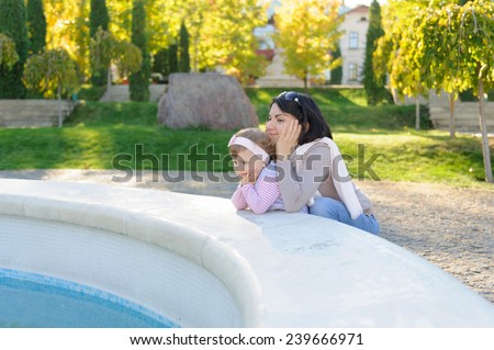 mother and daughter looking at fountain in yard